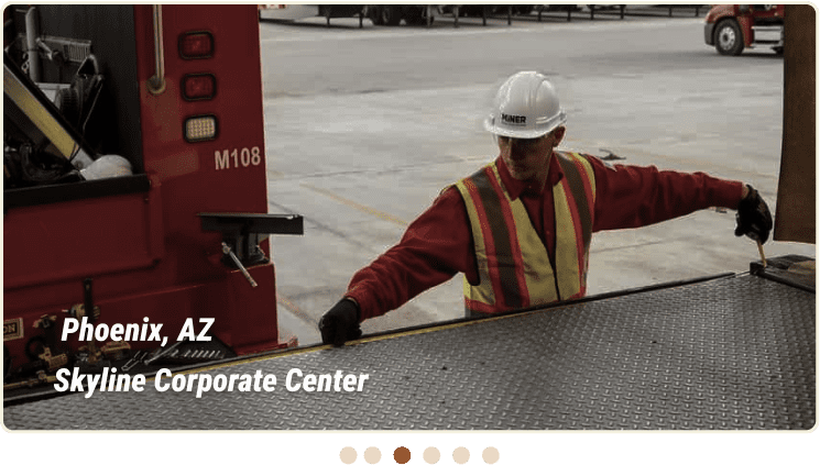 A worker in a safety vest and hard hat measures the edge of a loading dock at Skyline Corporate Center in Phoenix, AZ, ensuring precise Commercial Dock and Door Solutions.
